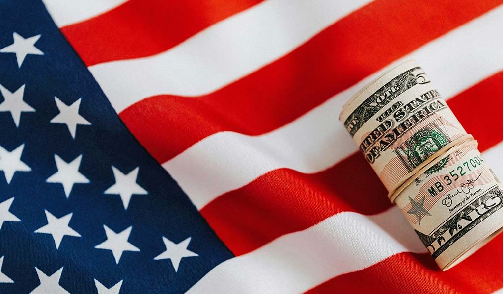 Roll of Dollar Bills on American Flag